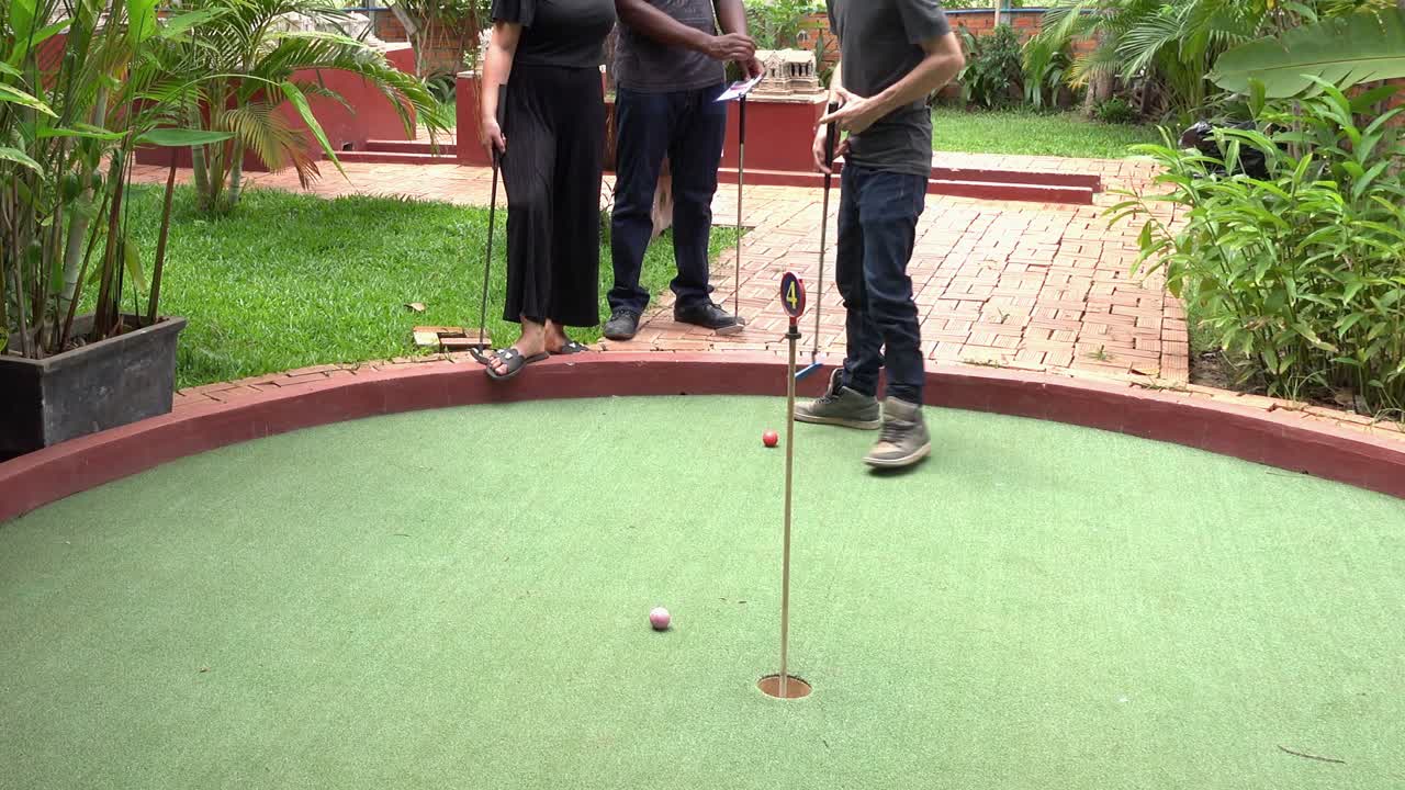 gente divirtiéndose en el green del campo de minigolf