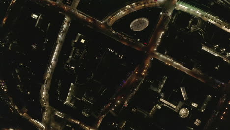 AERIAL:-Slow-Overhead-Shot-of-City-at-Night-with-Lights-and-Traffic,-Cologne,-Germany