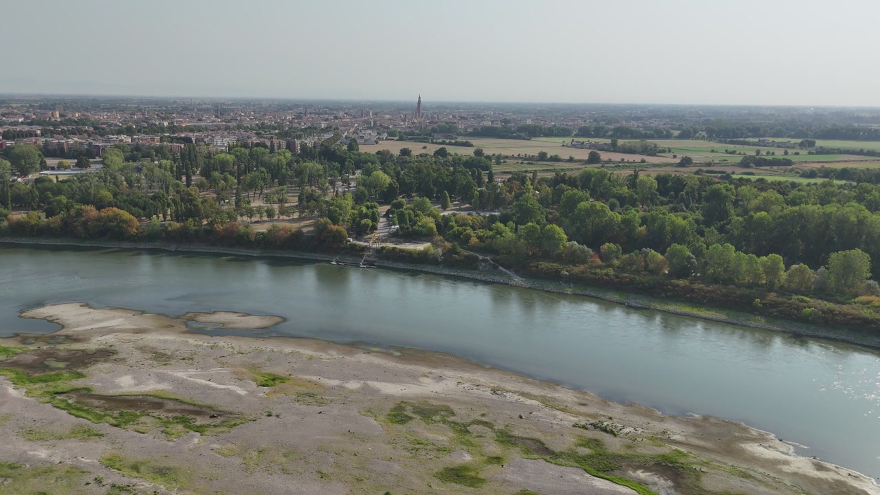 Sequía del río Po vista desde Castelvetro Piacentino hacia Cremona, con sedimentos aluviales expuestos, aguas poco profundas y bosque de ribera, Emilia-Romaña, Italia, vista aérea con dron