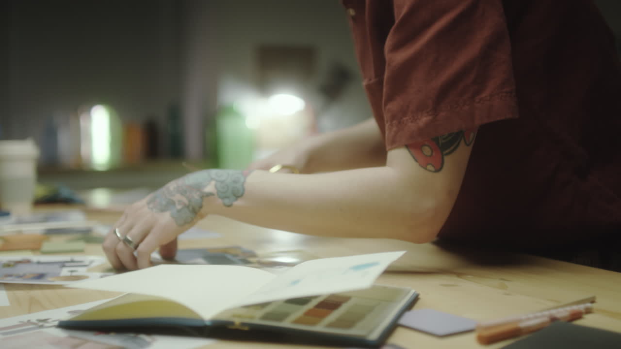Young Artist with Tattoo and AirPods Concentrating on Work