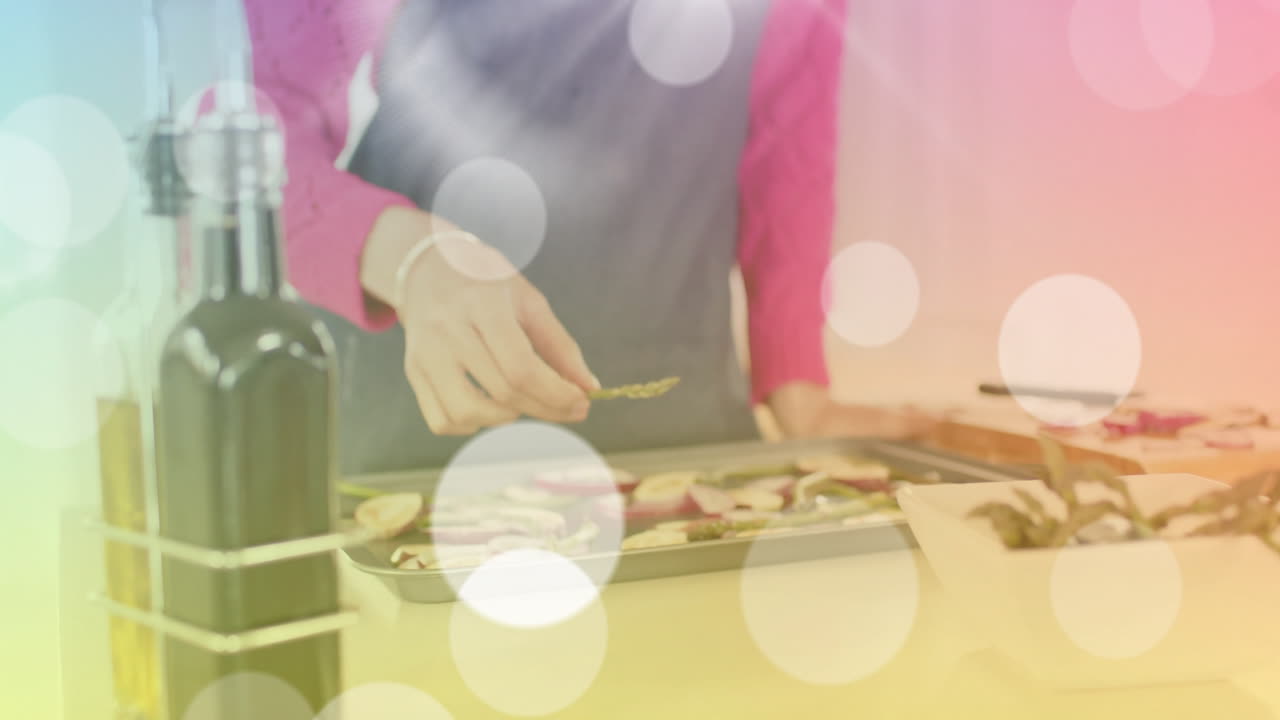 두 인종의 여성이 부으로 은 채소를 배열하고, 빛의 반점 위에서 요리하고 있습니다.