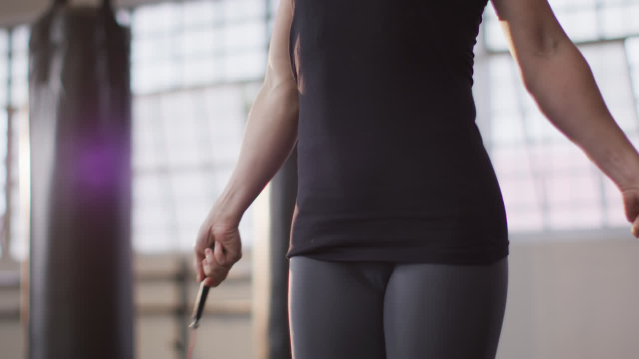 Donna caucasica in forma che si allena con la corda in palestra