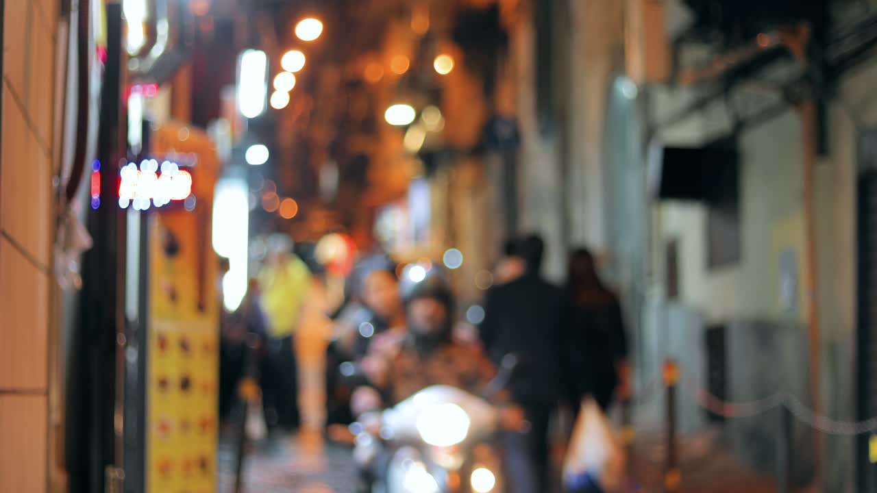 스쿠터와 자전거를 타고 있는 야간 교통, 도시 배경, 은 거리의 불명확한 불빛으로 색이 흐릿한 보케 배경