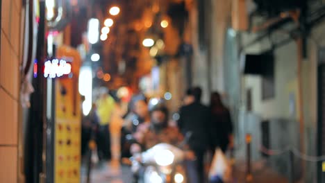 absract blurred bokeh night traffic with scooters and bikes urban backdrop. blurred colorful bokeh background with defocused lights of narrow street