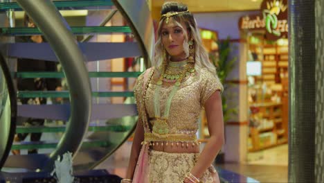 a young woman of east indian descent dressed in traditional indian attire in a shopping mall