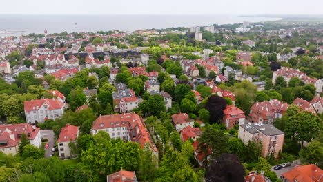 aerial footage of sopot, poland. lush greenery and red-roofed buildings create a vibrant landscape