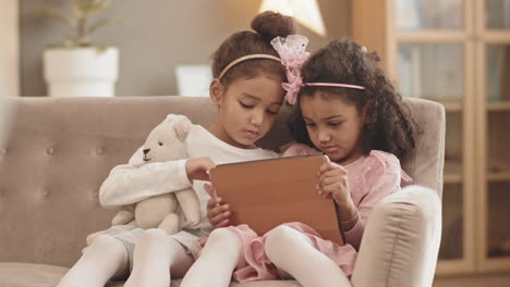 mixed-race sisters using tablet computer