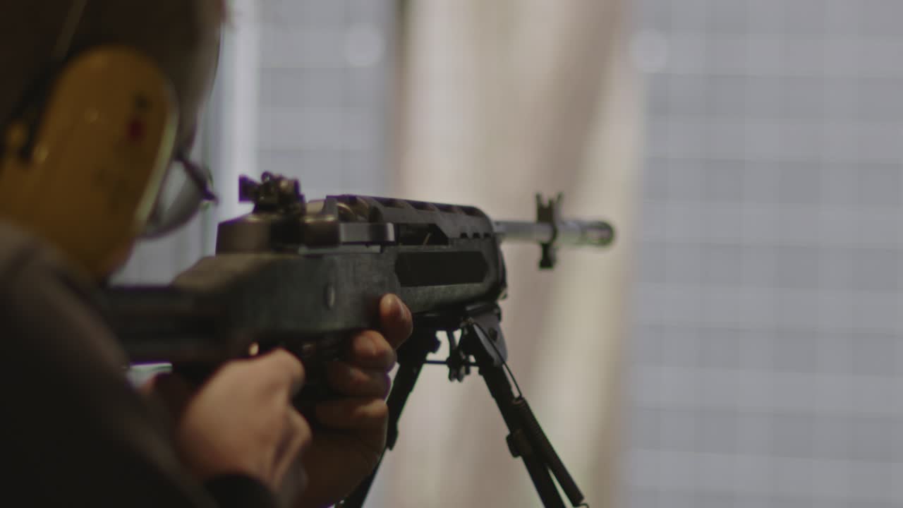 стрелок прицеливается и стреляет из винтовки ruger mini-14 на стрельбище в замедленном движении