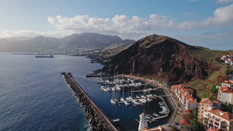 aerial view of a harbor and marina with mountains in the background