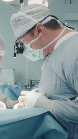 cirujanos con micro pinzas operan. médicos cualificados en uniformes estériles usan instrumentos para trabajar en pequeñas arterias coronarias en la sala de operaciones