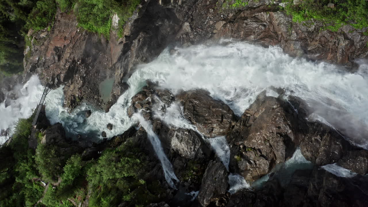 una poderosa cascada que se estrella sobre acantilados rocosos rodeados de exuberante vegetación