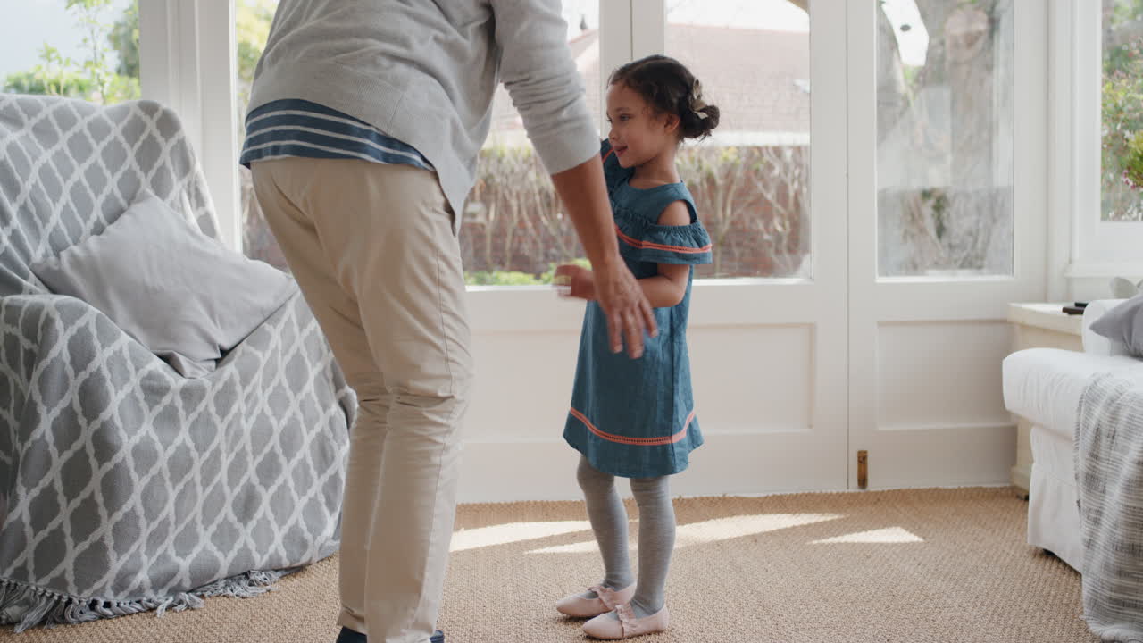 adorable little girl playfully dancing with granny having fun dance with granddaughter celebrating family weekend at home 4k