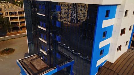 Beautiful aerial view of the facade of a modern office building with large windows in the facade. Filmed in the urban area of Abuja, Nigeria