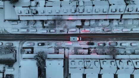 Top-down-aerial-tracking-shot-of-ambulance-responding-to-medical-emergency-with-lights-on