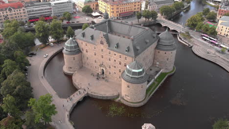 wide angle shot from a drone flying away from örebro castle in sweden