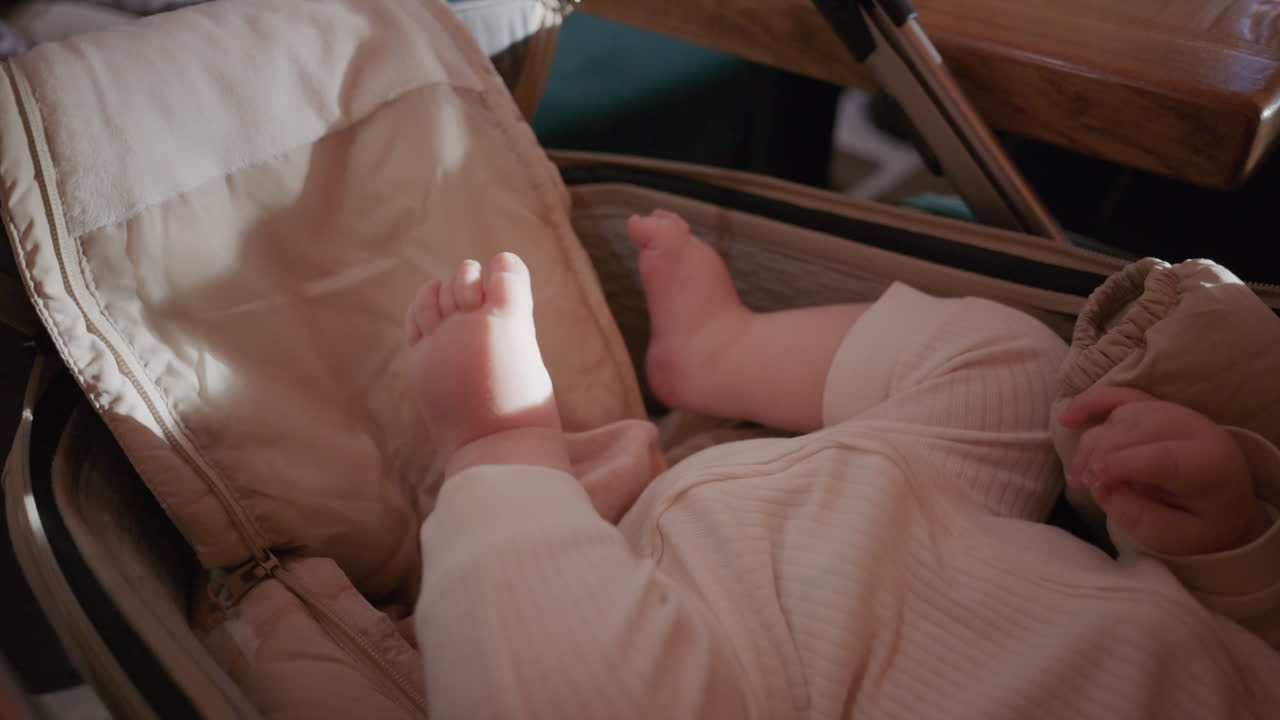 Bambino a riposo in un passeggino, vicino a un tavolo, in un ambiente al chiuso.