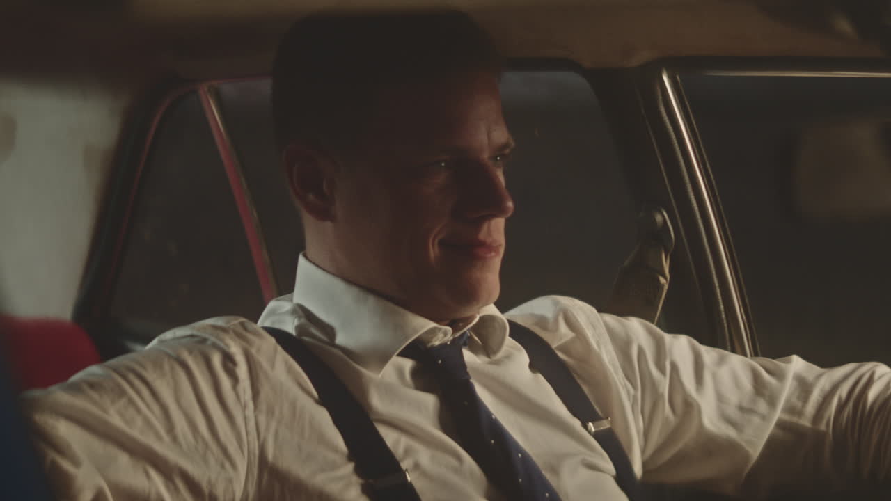 밤에 빈티지 자동차를 운전하는 남자