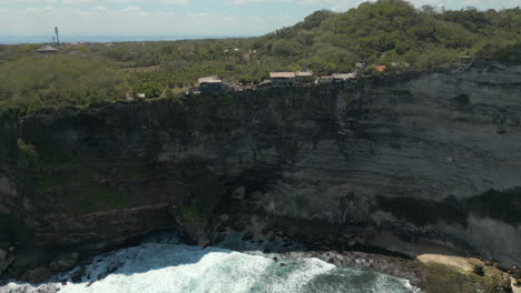 sheer uluwatu cliffs with restaurants perched on top bali indonesia drone track in 4k 60fps