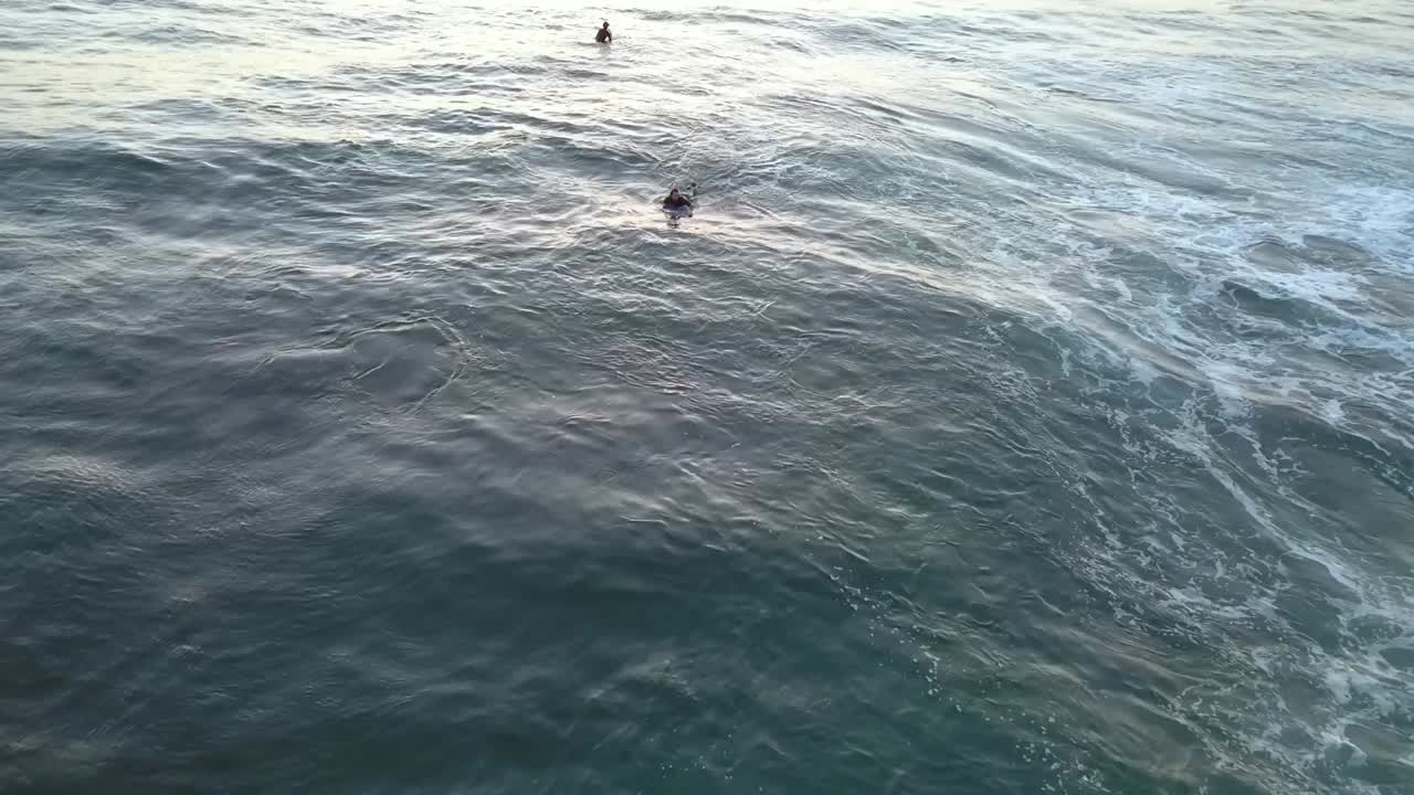 A surfer paddles to get the next big wave