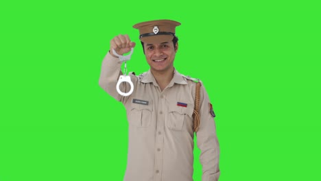 Fröhlicher-Indischer-Polizist-Posiert-Mit-Handschellen-Auf-Grünem-Bildschirm