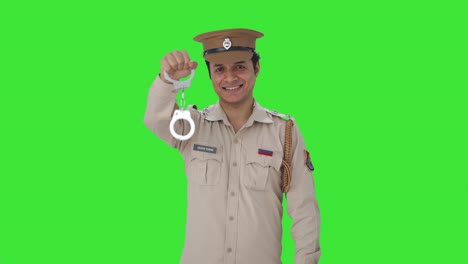 oficial de policía indio feliz posando con esposas pantalla verde