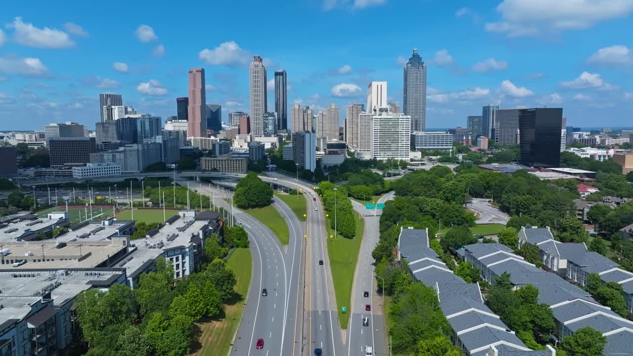 Traffic scene in Atlanta Downtown. Skyline with towers and skyscrapers in distance. Modern residential apartments in suburbia. Georgia, USA. Summer day with colored trees