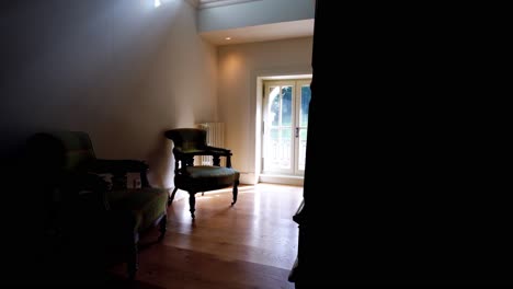 nicely decorated indoor household, slowly moving footage capturing ambience of window with chairs, stylishly furbished wooden furniture, french style house design