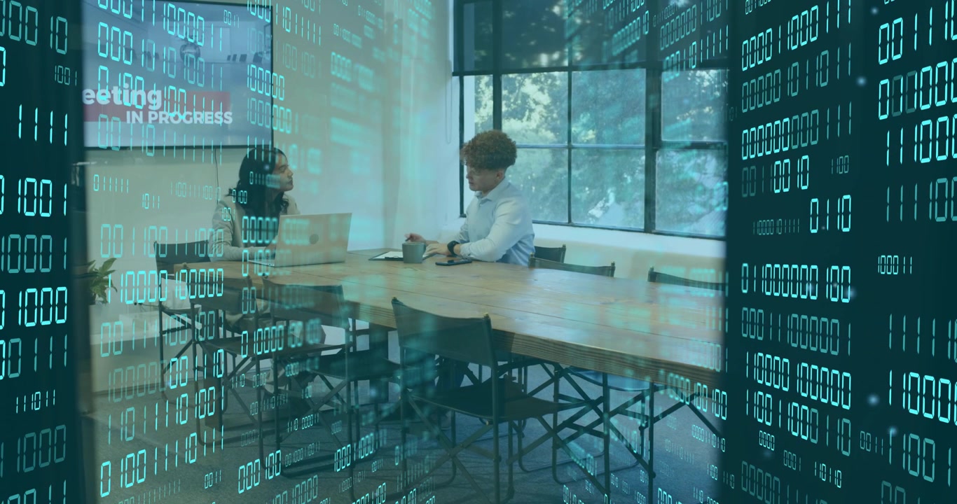Colleagues driving data discussion by typing on laptop with transparent binary overlay scrolling