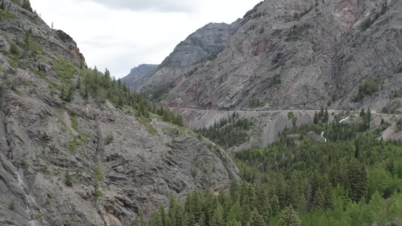 cañón de caja de colorado en las montañas rocosas del oeste con camino debajo de la pared de roca, tiro aéreo