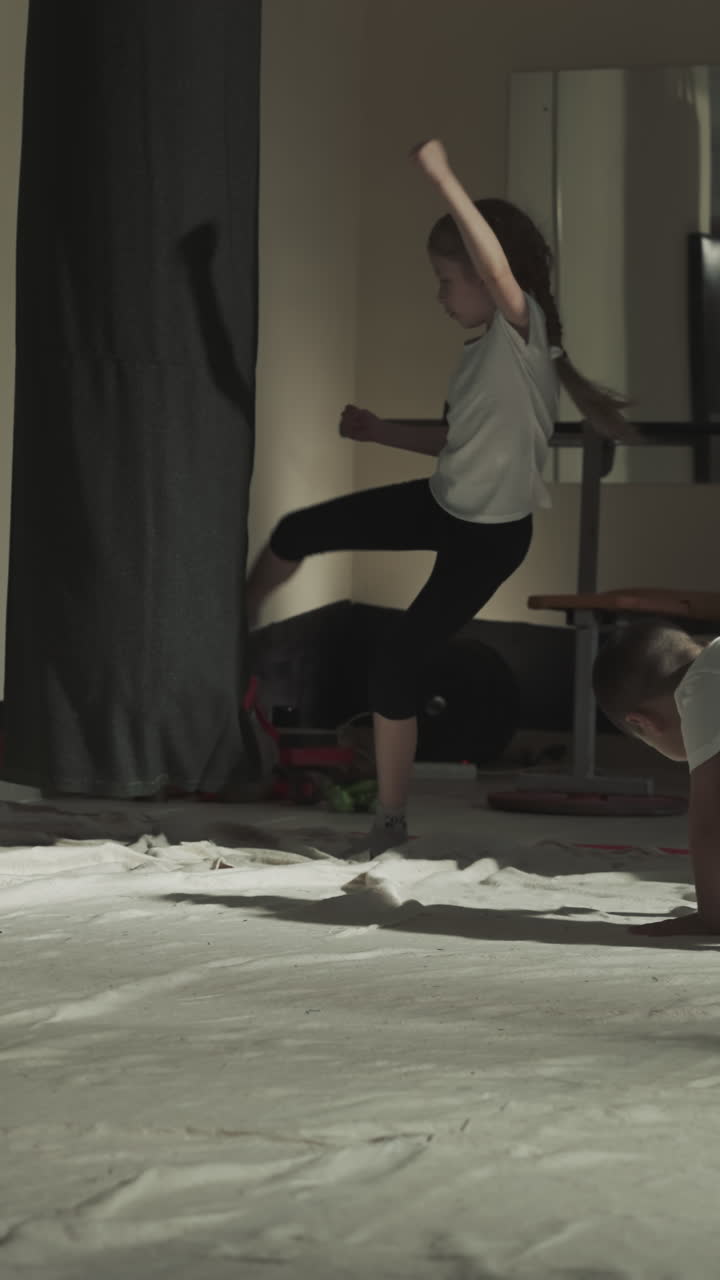 los niños se levantan y atacan bolsas de boxeo en el gimnasio. el equipo de niños pequeños hace patadas en la lección de artes marciales en la clase en cámara lenta. atletas junior en el club