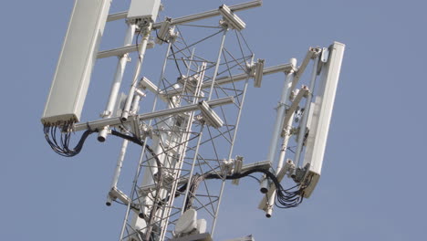 Mástil-De-Telefonía-Móvil-5g-Contra-El-Cielo-Azul,-Tiro-Tele-Pan-A-La-Derecha