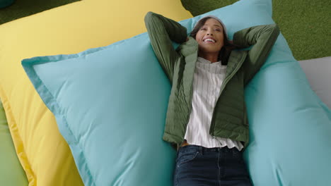 top view successful african american business woman jumping on colorful pillows smiling happy relaxing female resting enjoying success in trendy office workplace