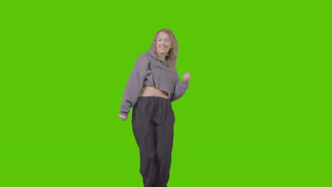 Full-Length-Studio-Shot-Of-Young-Woman-Having-Fun-Dancing-Against-Green-Screen-2