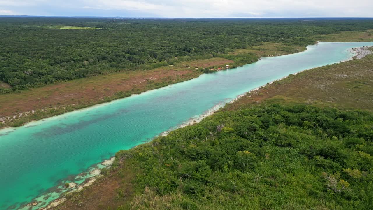 Aerial view of Bacalar's turquoise lagoon and lush green landscape