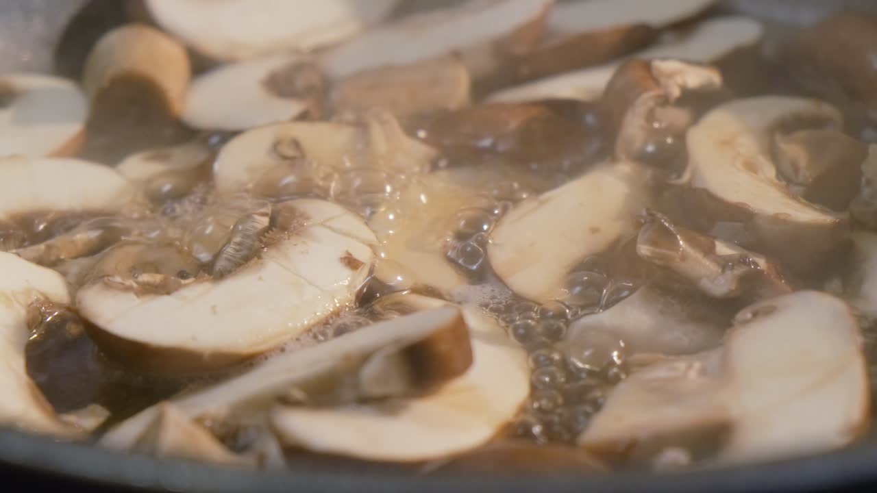 primer plano de hongos recién cortados cocinando en una sartén para una deliciosa receta saludable