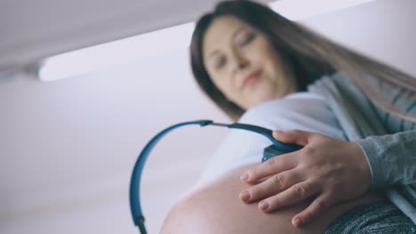 pregnant-woman-listens-to-music-with-future-baby-dancing