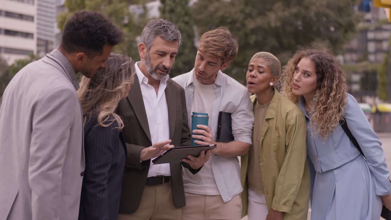 Group of business people looking at a tablet outdoors