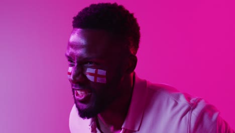 video de un alegre aficionado al deporte afroamericano con la bandera de inglaterra en un relámpago rosa de neón