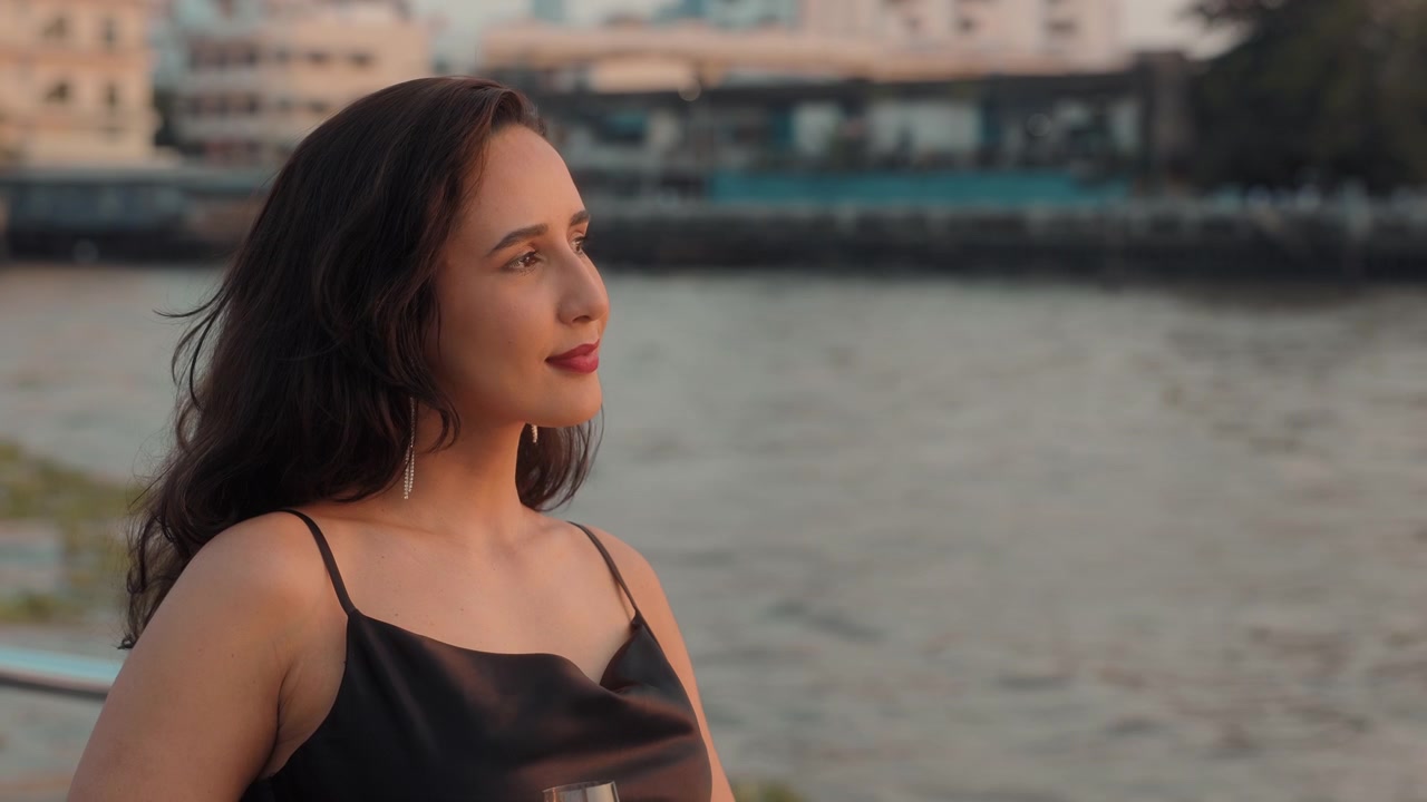 Elegant Woman Looking at the City River at Sunset