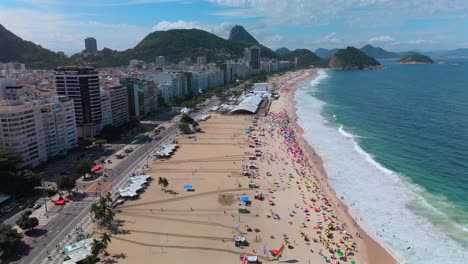 aerial flyover of sunny copacabana beach with sugarloaf and towering rio skyscrapers