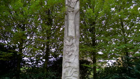 stone monument with carved animals and green trees in background at thulsfelder talsperre, germany