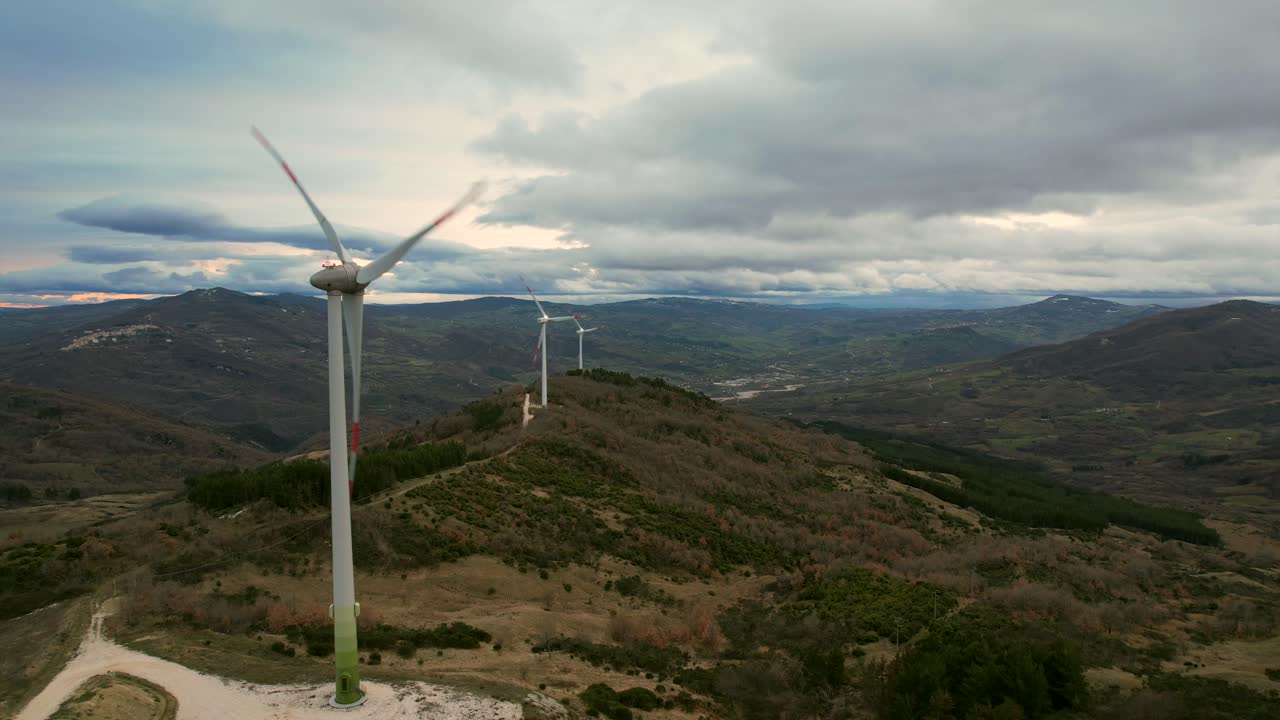 este es un video de un parque eólico con múltiples molinos de viento, filmado cerca de san giovanni lipooni en italia