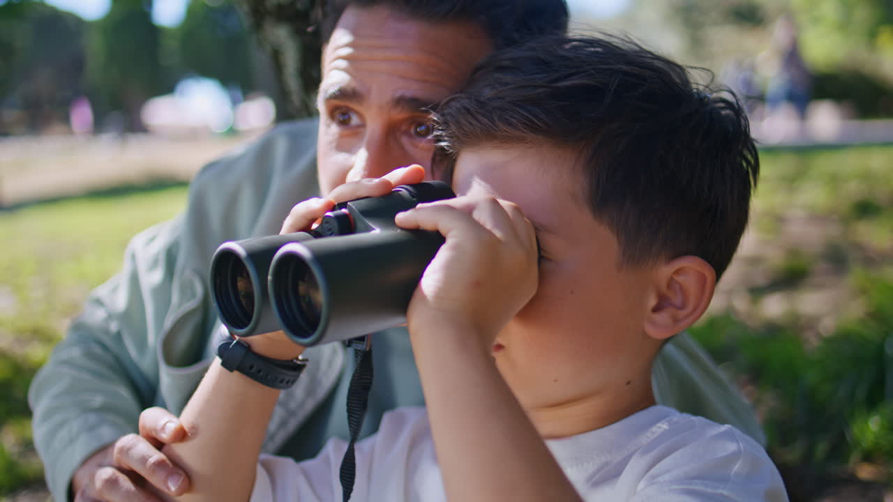 Family exploring new places looking binoculars birdwatching on nature closeup