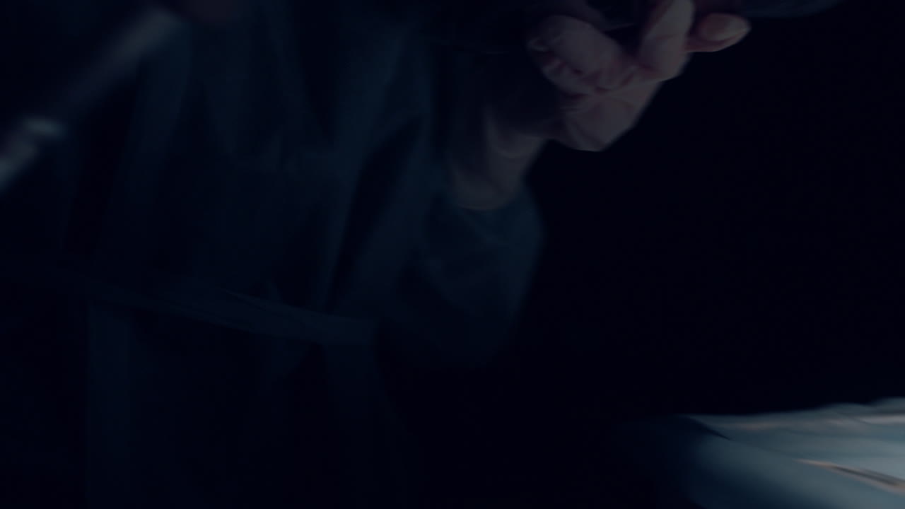 asistente entregando herramientas quirúrgicas al practicante oscuro de la sala de operaciones de cerca.