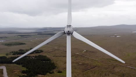 Close-up-drone-shot-of-the-top-of-a-Scottish-wind-turbine-as-it-spins