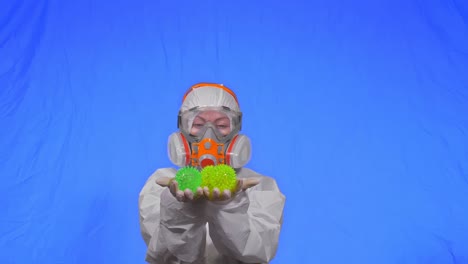 doctor in respirator show a virus model. slow motion. woman wearing protect medical aerosol spray paint mask. green ball spike thorn.