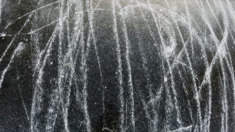 worn ice with dynamic skate marks showing winter activity from above, latvia