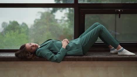 worn-out lady entrepreneur settles on windowsill. businesswoman craves moment of stillness among office chaos. quiet sanctuary during bustling day