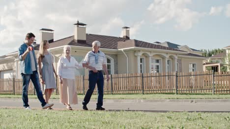 young family walking with elderly couple