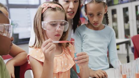 Focused-diverse-female-teacher-and-elementary-school-schoolgirls-in-lab-in-slow-motion